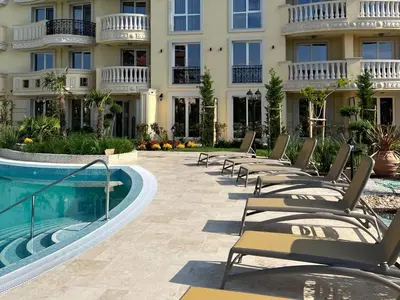 a hotel with a swimming pool and lounge chairs at Golden leaf, swimming pool view in Ravda