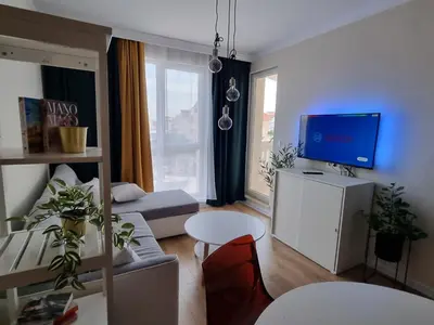 a living room with a couch and a tv at Golden leaf, swimming pool view in Ravda