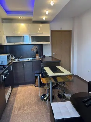 a kitchen with a table and a counter top at Апартамент Ломбарди in Varna City