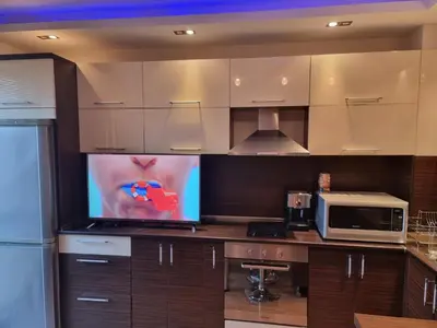 a kitchen with a microwave and a tv on a counter at Апартамент Ломбарди in Varna City