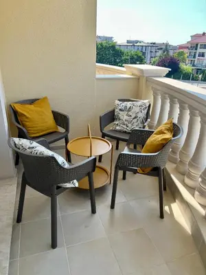 three chairs and a table on a balcony at Sunny apartment in Bellicity complex in Ravda