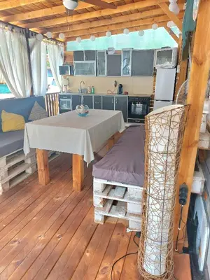 a kitchen with a table and a couch and a kitchen at Каравана Summer time in Chernomorets