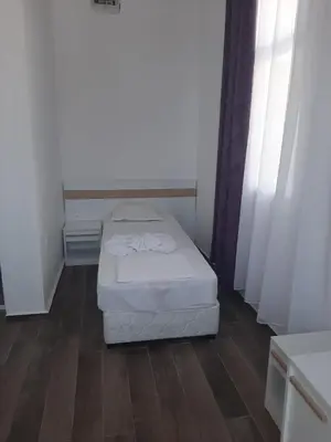 a small bedroom with a bed in a room at Апартаменти Жени in Tsarevo