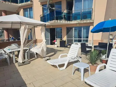 a group of chairs and umbrellas on a patio at Apartment with sea view in Sunny Beach