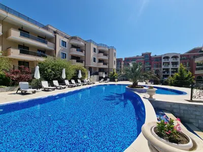 a large swimming pool with chairs and a building at Premium 2 bedroom flat at Millennium 2 in Sveti Vlas