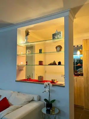 a living room with a white couch and shelves at Sea view Penthouse (YooBulgaria) in Obzor