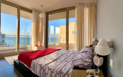 a bedroom with a bed and a large window at Sea view Penthouse (YooBulgaria) in Obzor