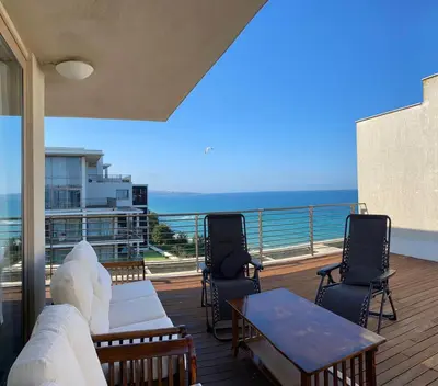 a balcony with chairs and a table and the ocean at Sea view Penthouse (YooBulgaria) in Obzor