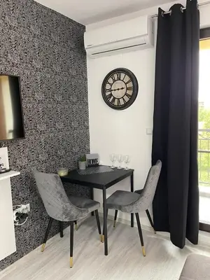 a dining room with a table and chairs and a clock at Villa Astoria 5. Sveti Vlas k.k. Elenite in Sveti Vlas