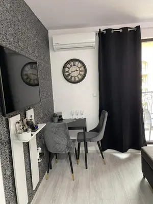 a dining room with a table and a clock on the wall at Villa Astoria 5. Sveti Vlas k.k. Elenite in Sveti Vlas