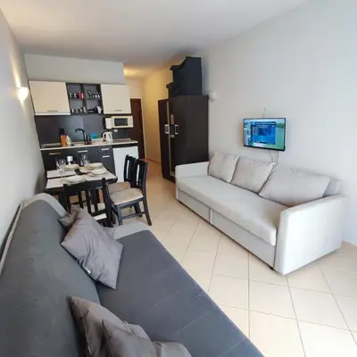 a living room with a couch and a kitchen at Sunset Beach 3 - Apartments in Sunny Beach