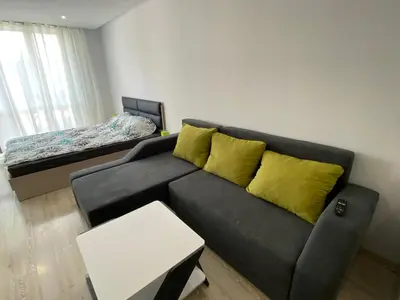 a living room with a black couch with yellow pillows at PARADISO 'В' 402 Private Apartment Nessebar in Nesebar
