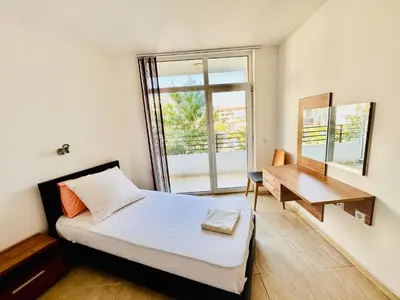a bedroom with a bed and a desk and a window at Cozy Mood Two-bed flat in Sunny Beach in Sunny Beach