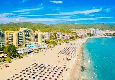 a beach with umbrellas and people on the beach at Cozy Mood Two-bed flat in Sunny Beach in Sunny Beach