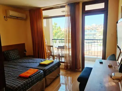 a bedroom with a bed and a balcony with a view at апартамент под наем на първа линия море in Sozopol