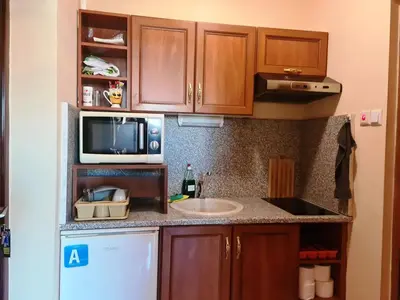 a kitchen with a sink and a microwave at апартамент под наем на първа линия море in Sozopol