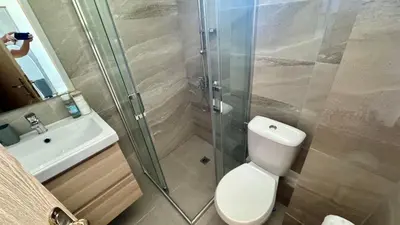 a bathroom with a shower and a toilet and a sink at Turtle Apartment Sunny Beach in Sunny Beach