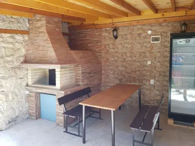 an outdoor kitchen with a wooden table and a wood stove at Villa Nikoli in Nesebar