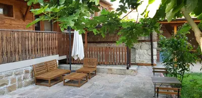 a patio with two chairs and an umbrella at Villa Nikoli in Nesebar