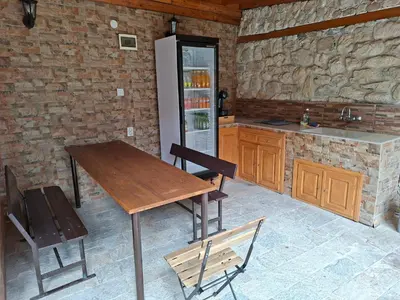 a kitchen with a wooden table and a refrigerator at Villa Nikoli in Nesebar