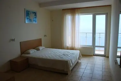 a bedroom with a bed and a large window at Coral Beach Apartment in Sveti Vlas