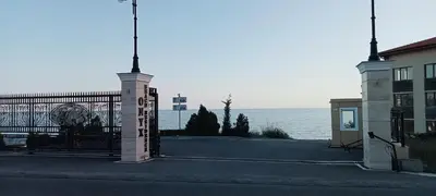 a gate with a sign on it next to the ocean at Coral Beach Apartment in Sveti Vlas