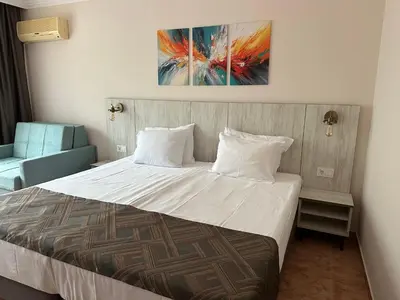 a bedroom with a bed and a painting on the wall at Oleander House and Tennis Club in Sunny Beach