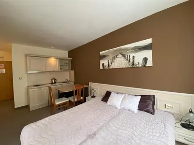 a bedroom with a bed and a desk and a kitchen at AVALON D202 Private Studio Sunny Beach in Sunny Beach