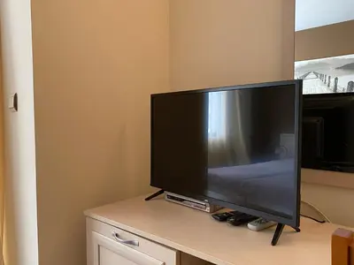 a flat screen tv sitting on top of a table at AVALON D202 Private Studio Sunny Beach in Sunny Beach