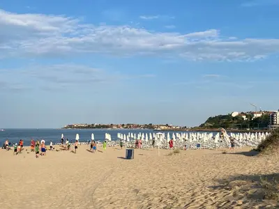 a group of people on a beach with chairs and umbrellas at AVALON D202 Private Studio Sunny Beach in Sunny Beach