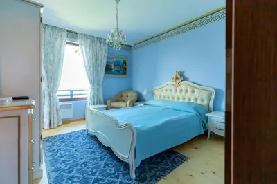 a blue bedroom with a bed and a chair at Luxury 2 bedroom villa in Sozopolis in Sozopol