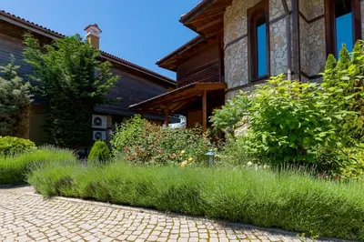 a garden in front of a house with tall grass at Luxury 2 bedroom villa in Sozopolis in Sozopol