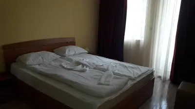 an unmade bed in a bedroom with a window at Victoria Perla Apartment in Sunny Beach