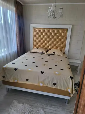 a bedroom with a bed with a large headboard at VIP Аpartament in Sunny Beach