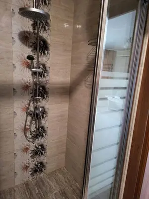 a shower with a glass door next to a staircase at VIP Аpartament in Sunny Beach