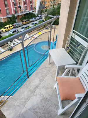 a balcony with a chair and a swimming pool at VIP Аpartament in Sunny Beach