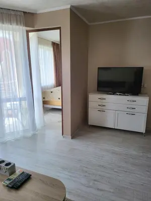 a living room with a flat screen tv on a dresser at VIP Аpartament in Sunny Beach