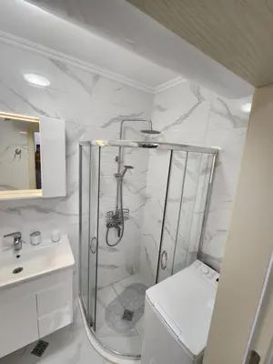 a white bathroom with a shower and a sink at VALENCIA GARDENS STUDIO LUX 4 per. in Nesebar