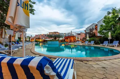 a large swimming pool with lounge chairs and umbrellas at Complex Sunrise by HMG - All Inclusive in Sunny Beach