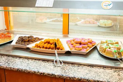 a buffet line with different types of donuts and pastries at Complex Sunrise by HMG - All Inclusive in Sunny Beach