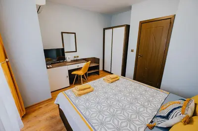 a bedroom with a bed with a desk and a chair at Miletia Suites in Sozopol