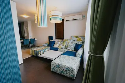 a living room with a blue couch and a chair at Miletia Suites in Sozopol