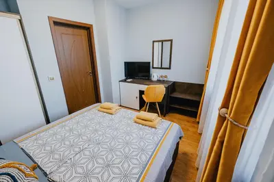 a small bedroom with a bed and a desk at Miletia Suites in Sozopol