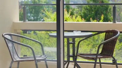 a table and two chairs on a balcony with a window at St. Sofia Beach Hotel in Kiten