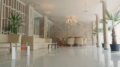 a lobby with white furniture and potted plants at St. Sofia Beach Hotel in Kiten