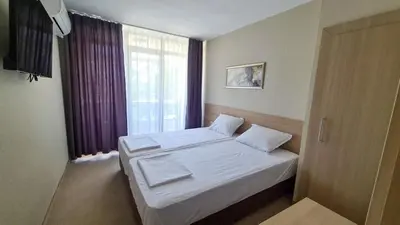 a small bedroom with a bed and a window at St. Sofia Beach Hotel in Kiten