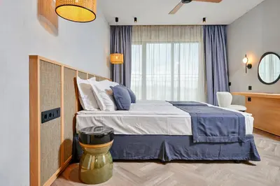 a bedroom with a large bed and a window at Hotel Fara - Marina Cape in Aheloy