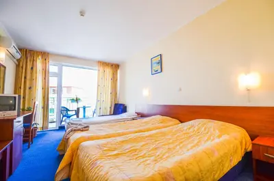 a hotel room with two beds and a television at Family Hotel Eliri in Nesebar