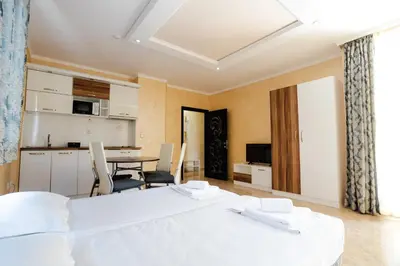 a bedroom with a bed and a table and chairs at K&E studios and apartments - All inclusive - Free parking in Sunny Beach