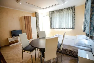 a room with a bed and a table and chairs at K&E studios and apartments - All inclusive - Free parking in Sunny Beach